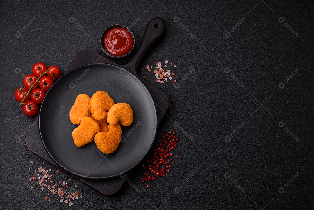 Deliciosos nuggets de frango crocantes frescos em um fundo escuro de concreto. Alimentos não saudáveis, fast food