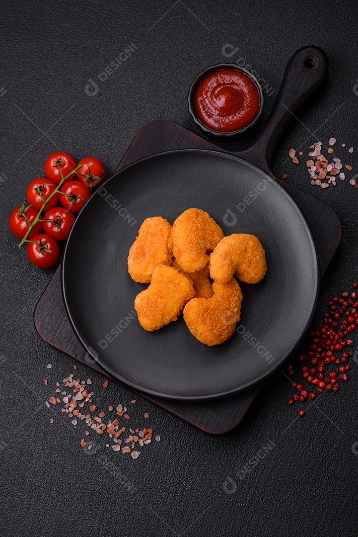 Deliciosos nuggets de frango crocantes frescos em um fundo escuro de concreto. Alimentos não saudáveis, fast food