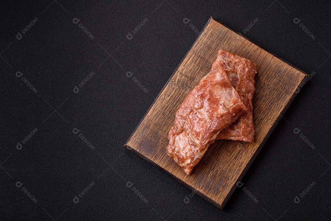 Costelinha de porco ou boi crua ao molho de mel com sal, especiarias e ervas preparadas para grelhar