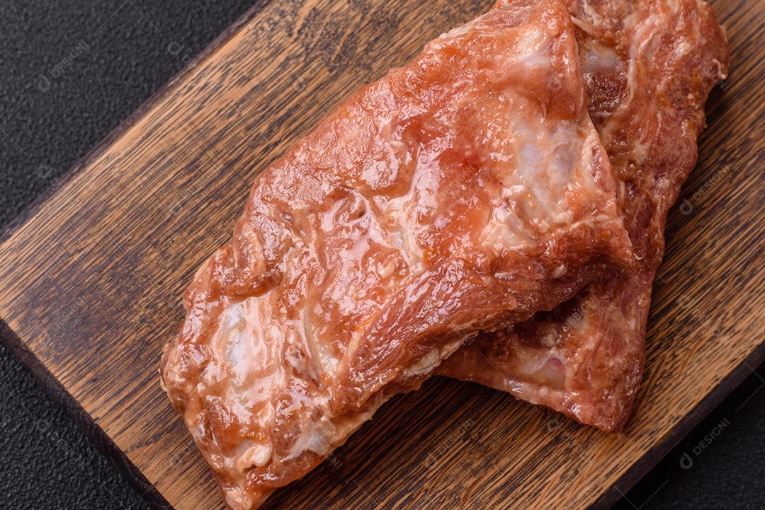 Costelinha de porco ou boi crua ao molho de mel com sal, especiarias e ervas preparadas para grelhar