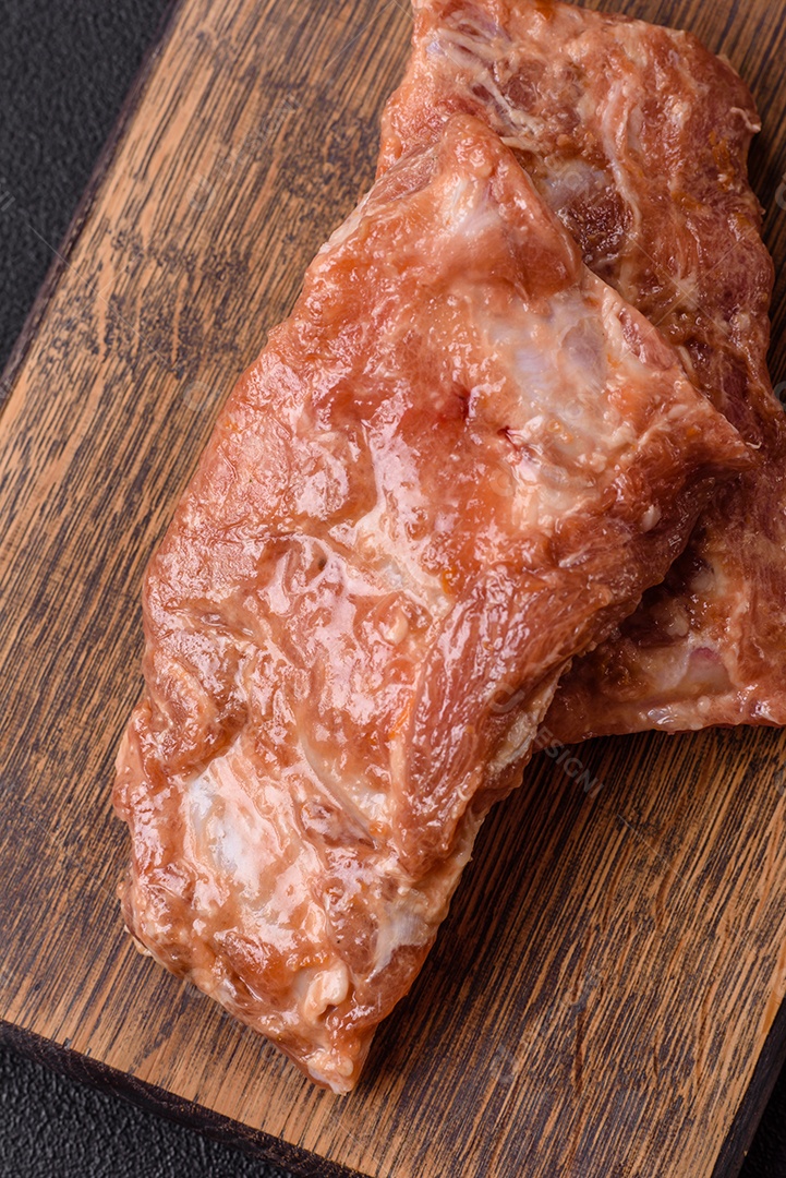 Costelinha de porco ou boi crua ao molho de mel com sal, especiarias e ervas preparadas para grelhar