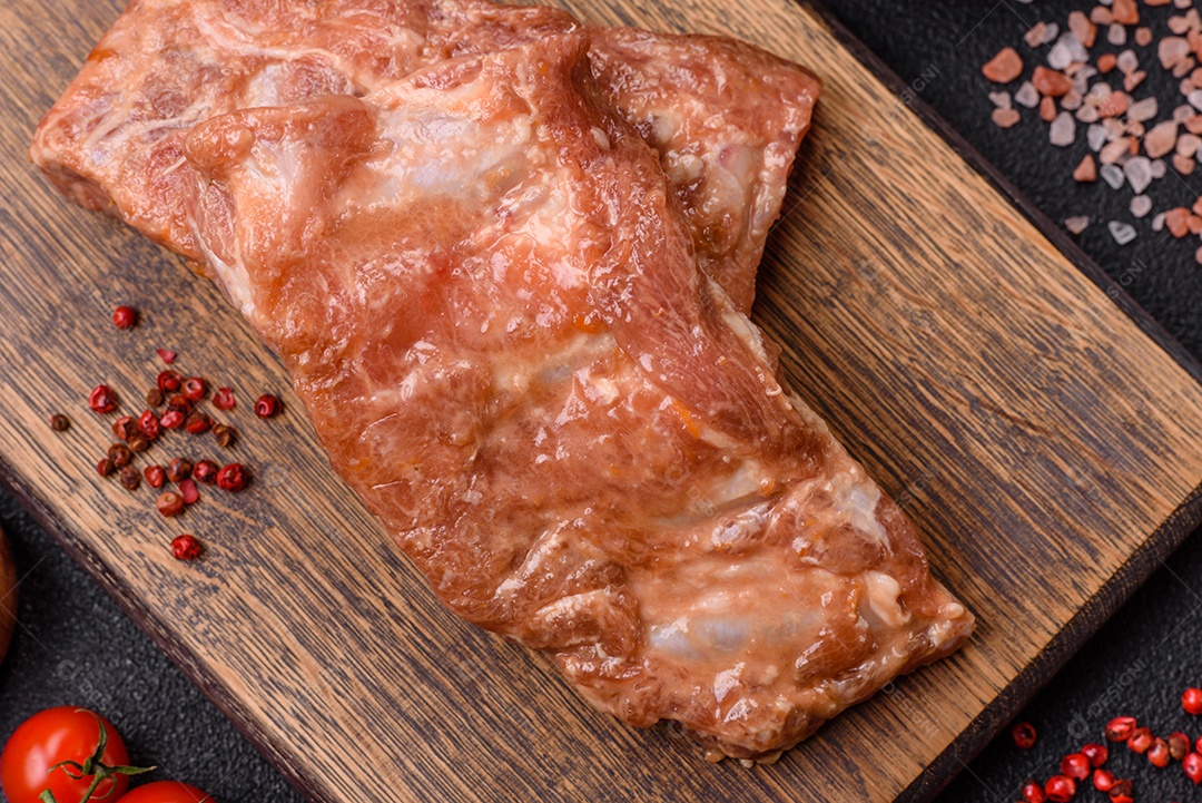 Costelinha de porco ou boi crua ao molho de mel com sal, especiarias e ervas preparadas para grelhar