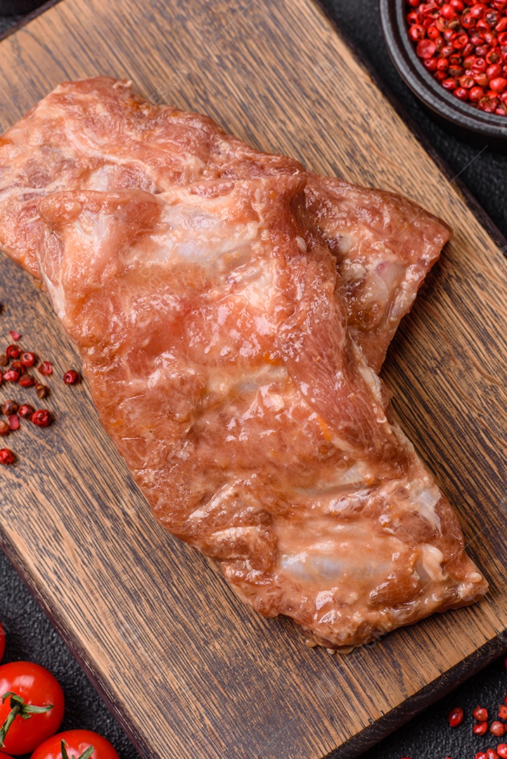 Costelinha de porco ou boi crua ao molho de mel com sal, especiarias e ervas preparadas para grelhar