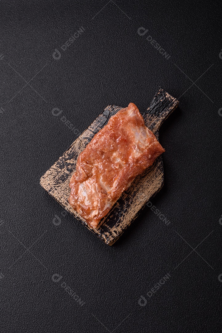 Costelinha de porco ou boi crua ao molho de mel com sal, especiarias e ervas preparadas para grelhar