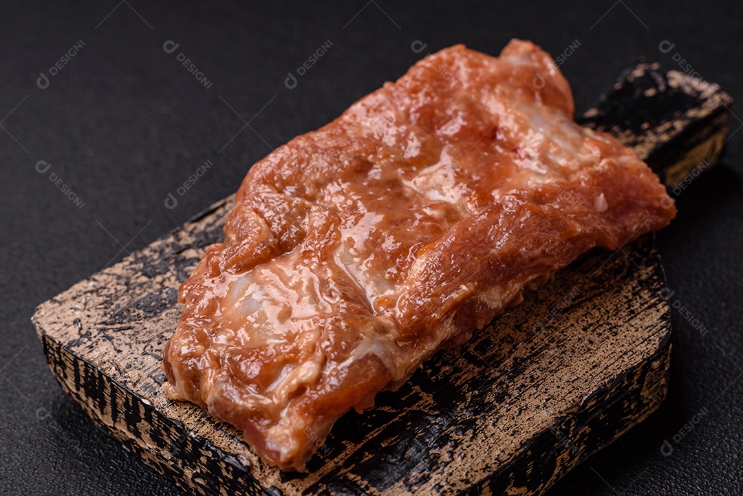Costelinha de porco ou boi crua ao molho de mel com sal, especiarias e ervas preparadas para grelhar