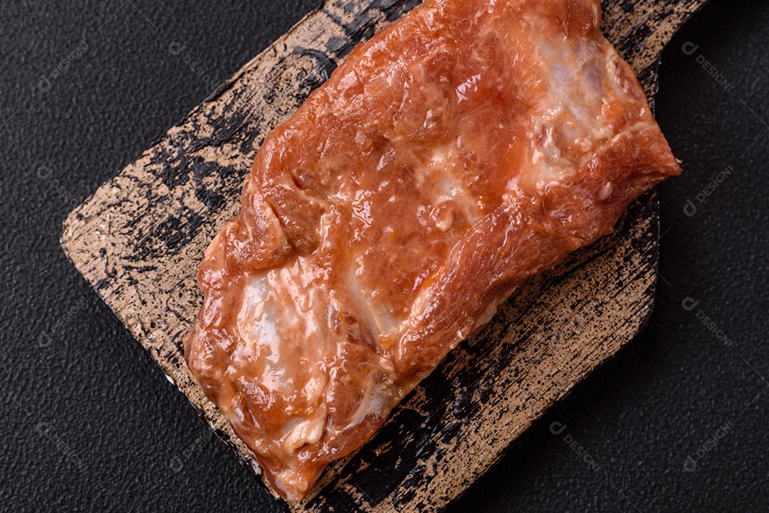 Costelinha de porco ou boi crua ao molho de mel com sal, especiarias e ervas preparadas para grelhar