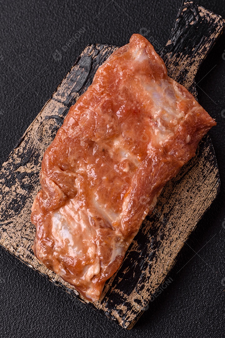 Costelinha de porco ou boi crua ao molho de mel com sal, especiarias e ervas preparadas para grelhar