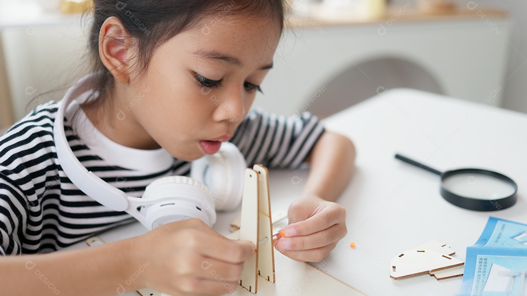 Garotinha concentrada montando seu objeto