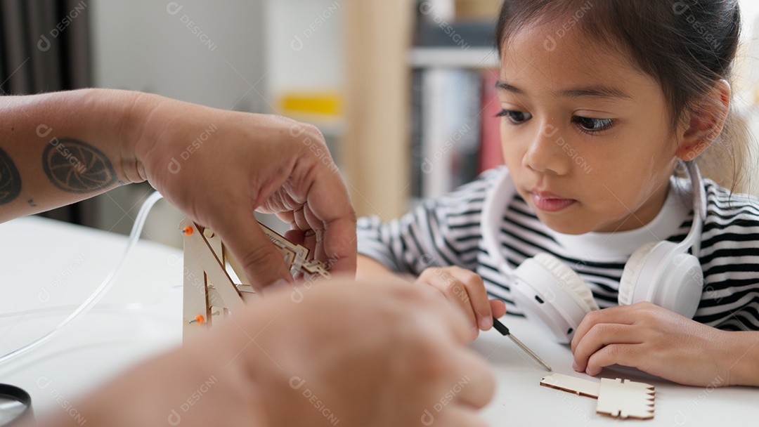 Pai ajudando sua filha na montagem de um objeto