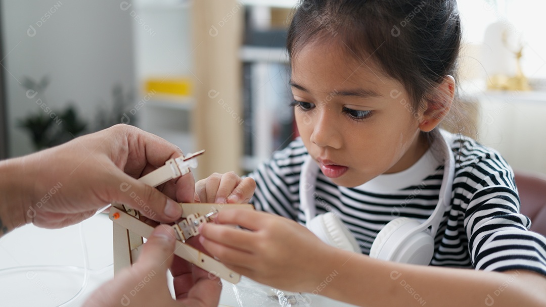 Garotinha montando seu objeto sozinha conceito de engenharia em casa