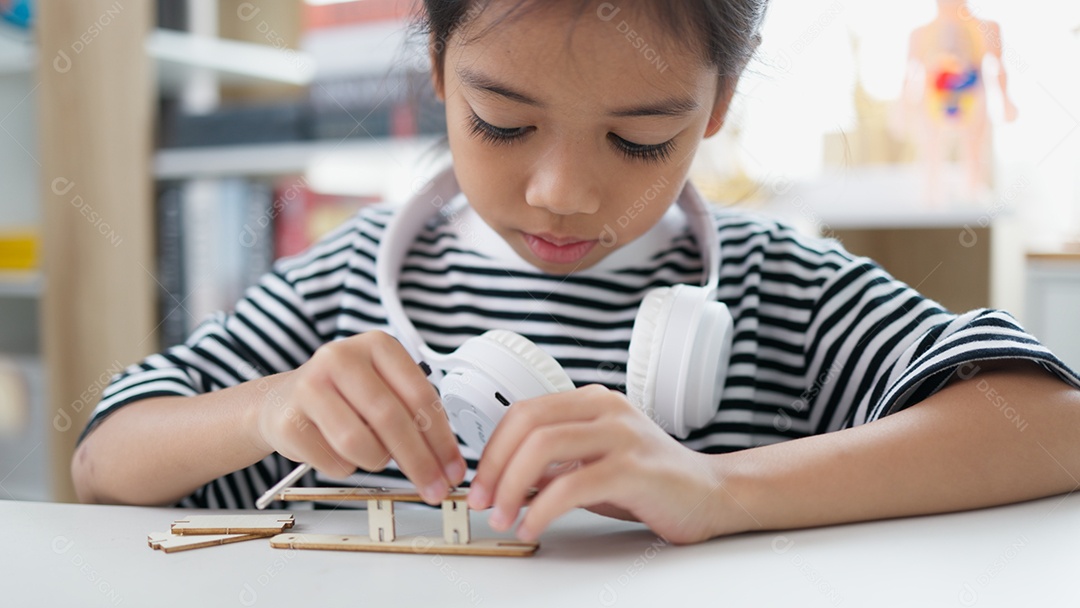 Garotinha montando seu objeto sozinha conceito de engenharia em casa