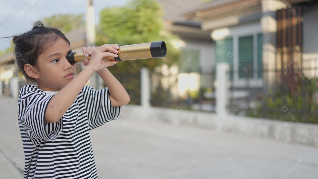 Criança feliz olhando para frente por um binoculo