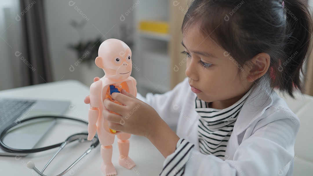 Garotinha asiática brincando com boneco anatômico