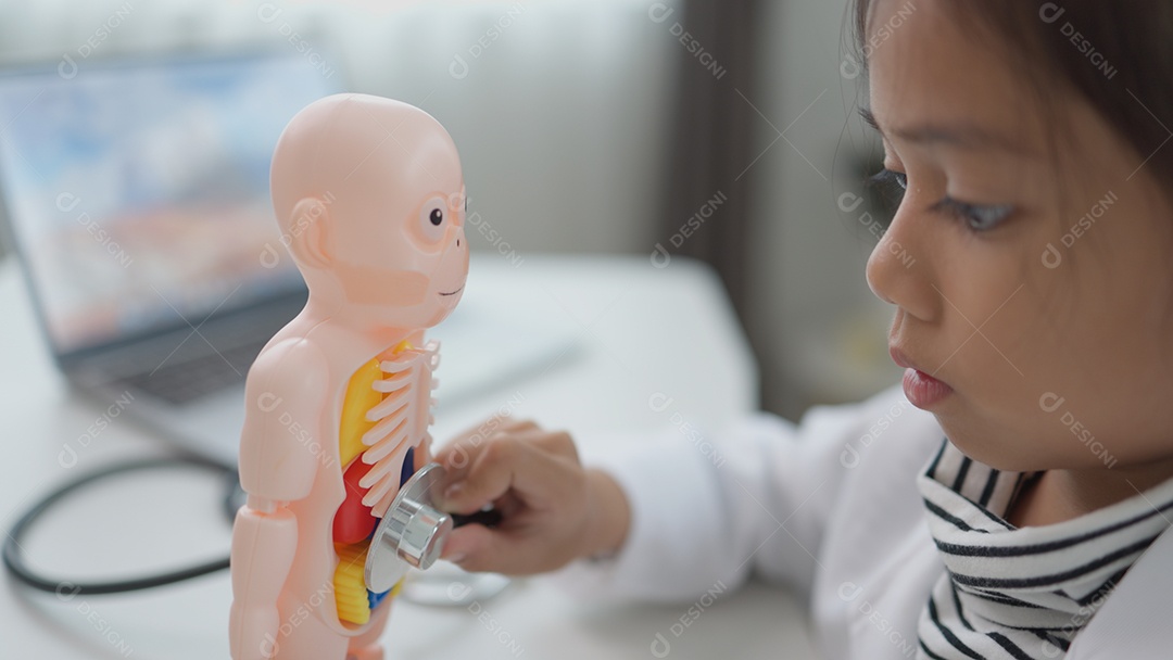 Garotinha asiática brincando com boneco anatômico