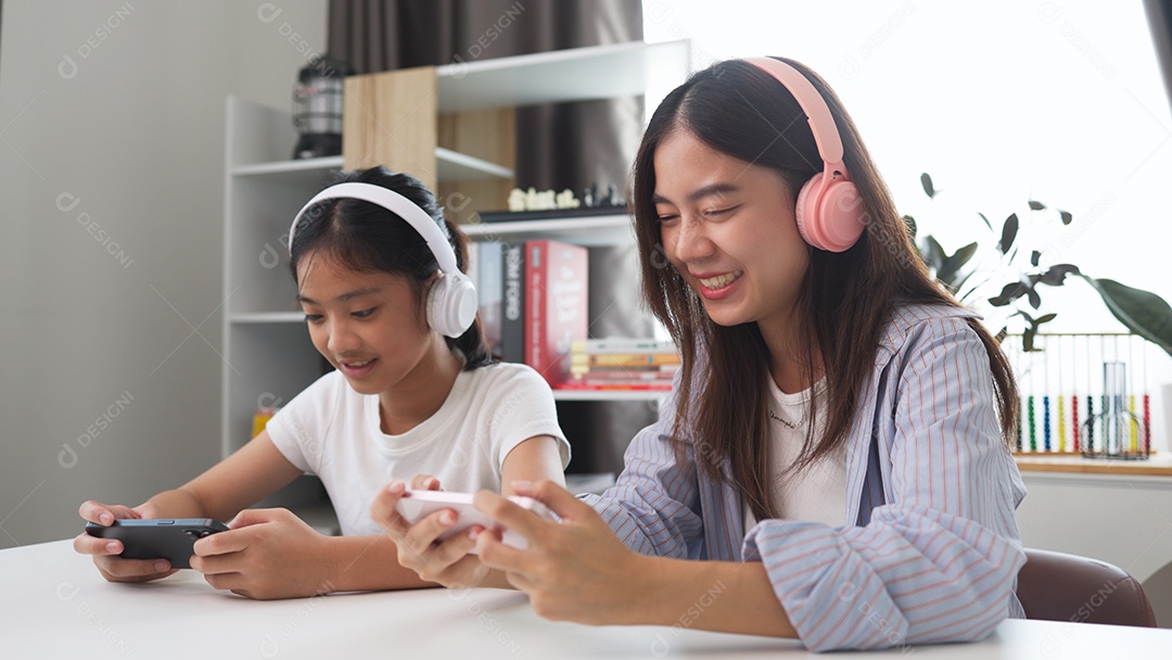 Garotas acessando celulares com fones de ouvido se divertindo