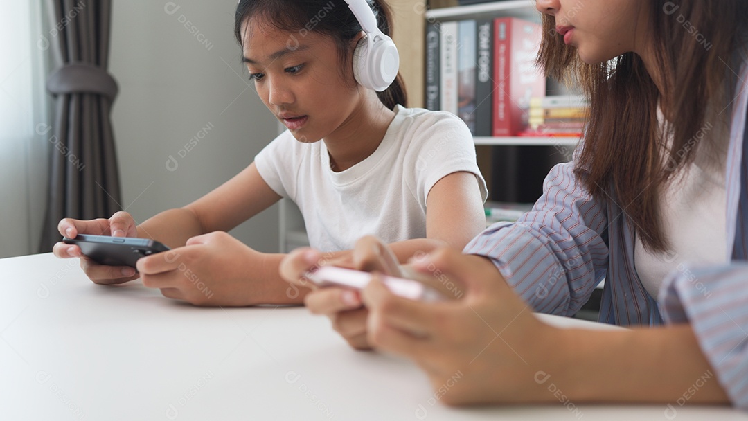 Garotas acessando celulares com fones de ouvido se divertindo