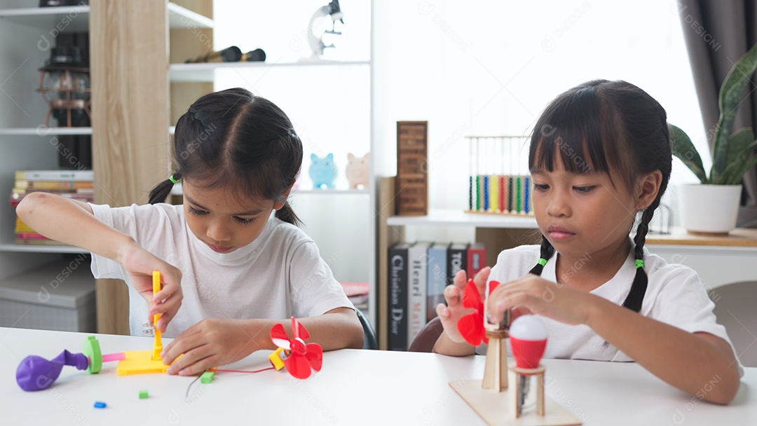 Duas crianças estudando e aprendendo em casa com brinquedo