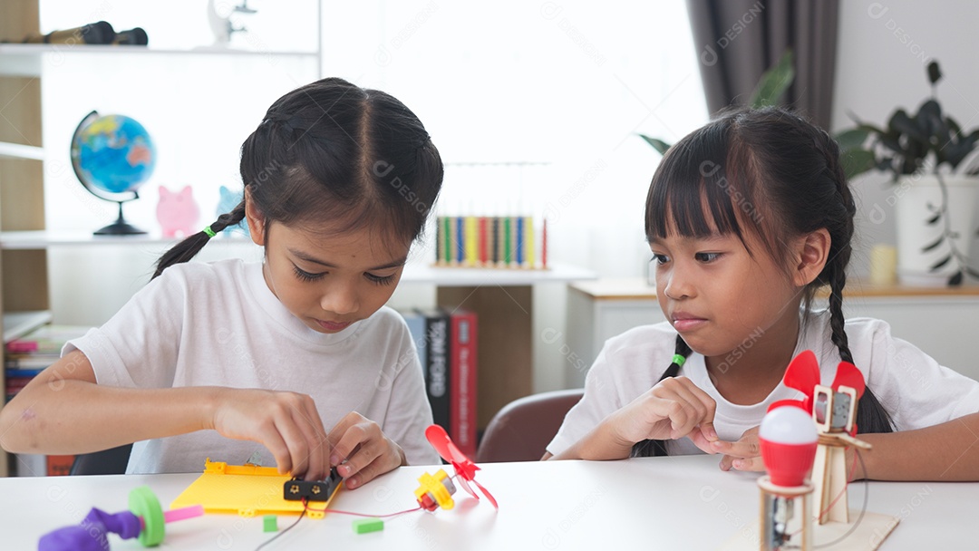 Duas crianças estudando e aprendendo em casa com brinquedo