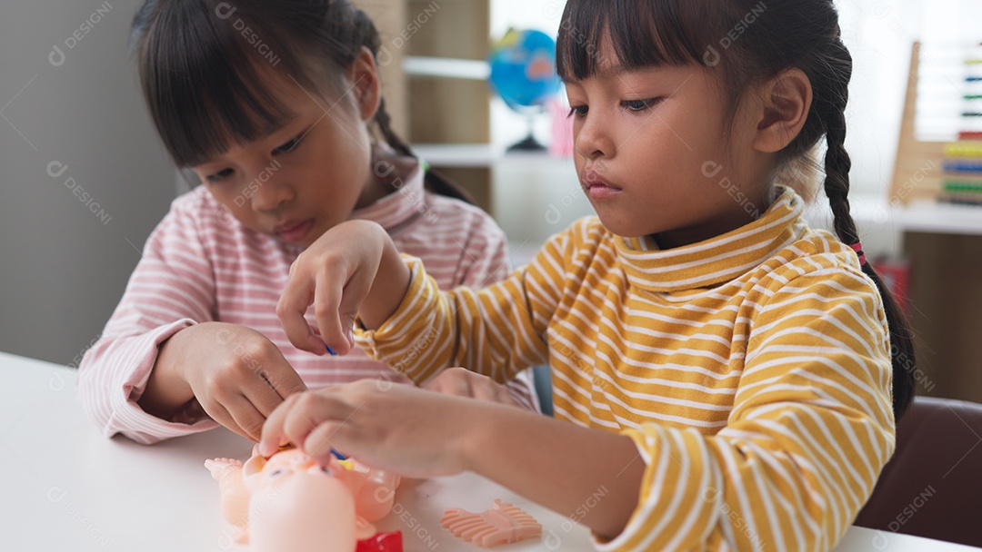 Duas meninas asiáticas montando brinquedo de corpo humano