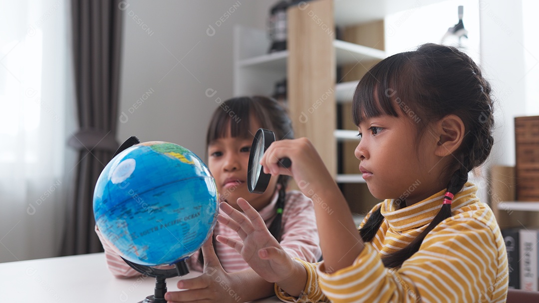 Duas meninas asiáticas estão aprendendo o modelo do globo