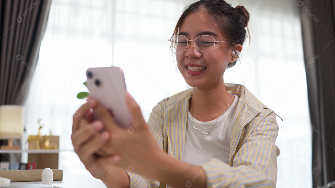 Jovem usando seu smartphone para conversar com amigos por meio de videochamadas