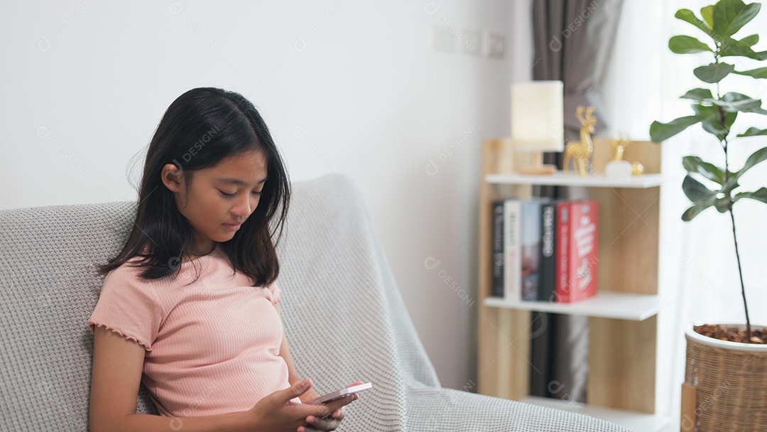 Garotinha asiática mexendo no celular