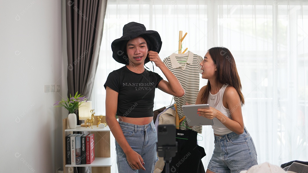 Garota e amiga LGBTQ transmitindo ao vivo as vendas de roupas e acessórios
