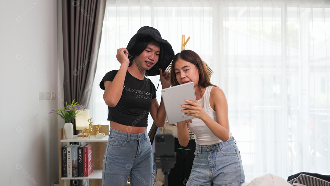 Garota e amiga LGBTQ transmitindo ao vivo as vendas de roupas e acessórios