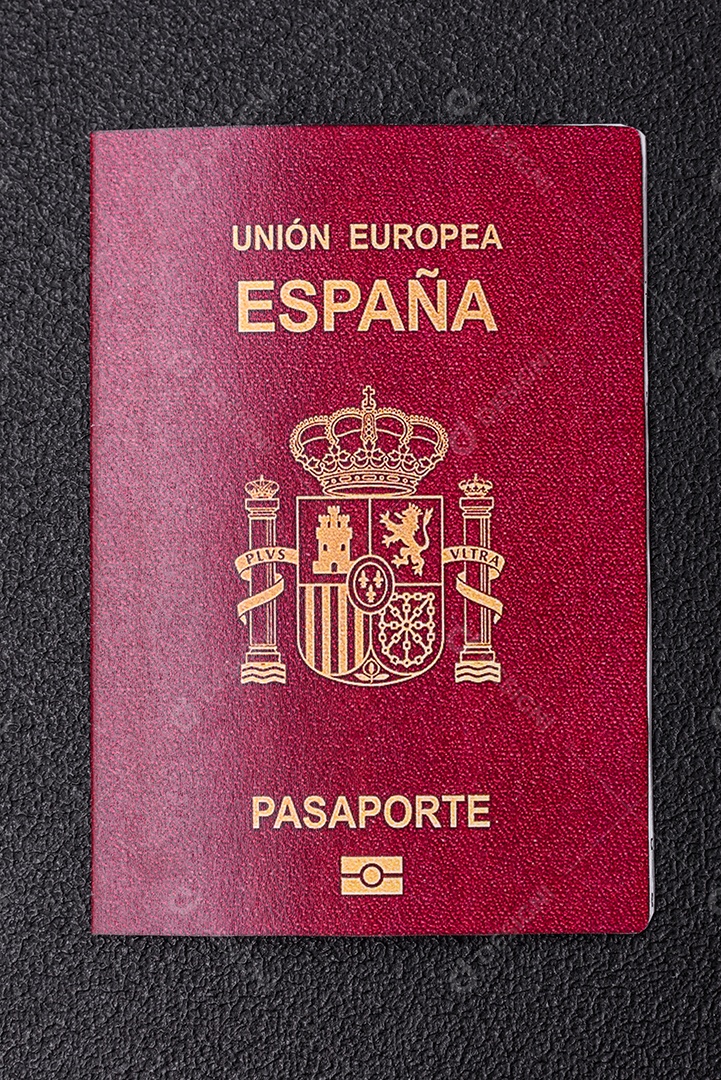 Passaporte internacional em papel físico de um cidadão espanhol sobre um fundo escuro de concreto