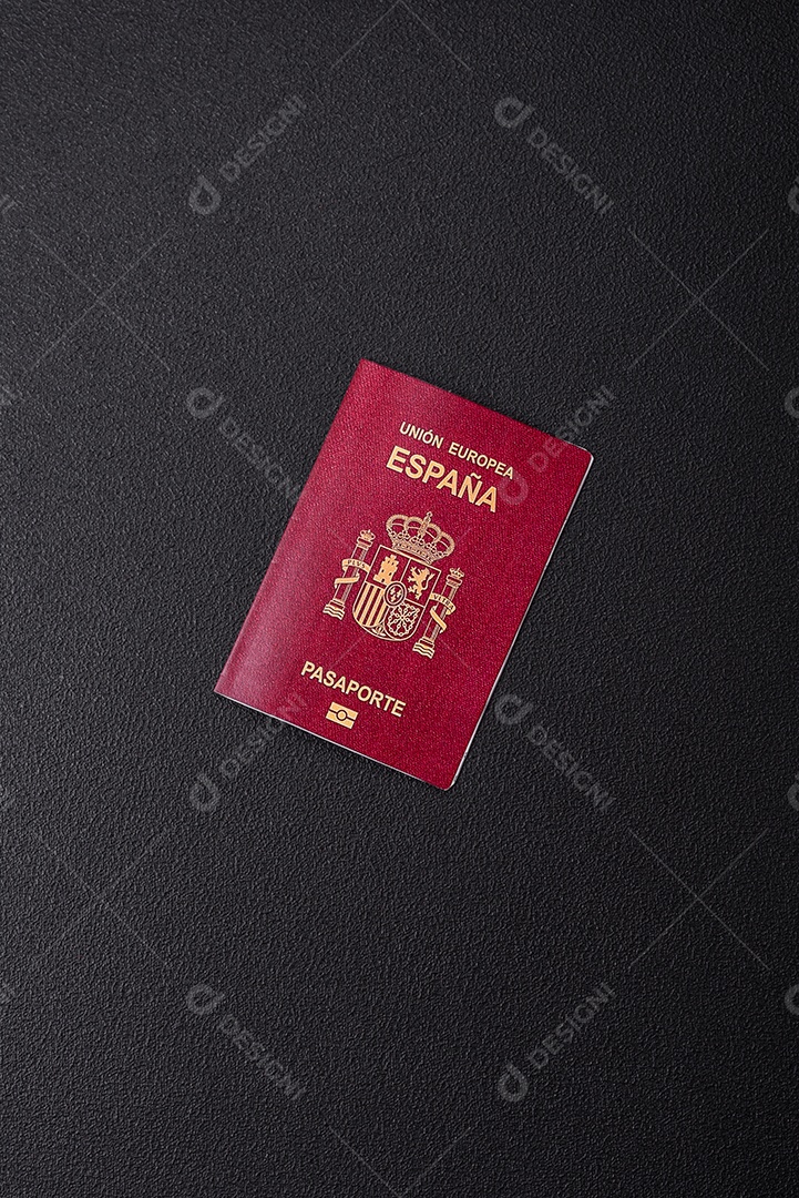 Passaporte internacional em papel físico de um cidadão espanhol sobre um fundo escuro de concreto