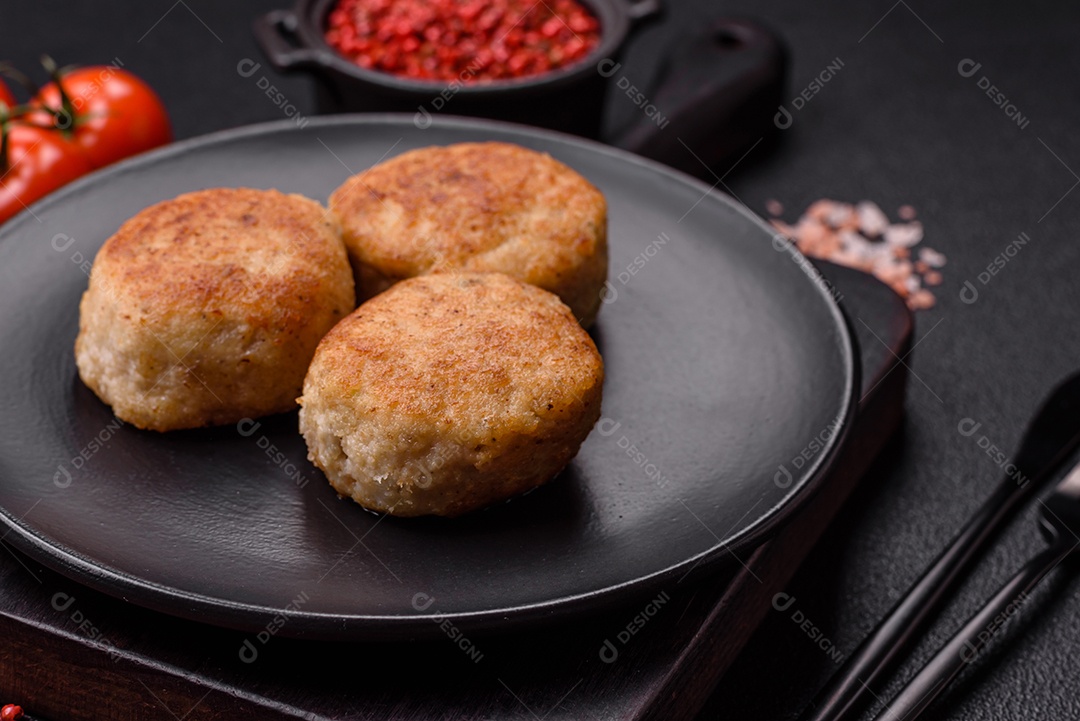 Deliciosas costeletas de peixe picado frito fresco com especiarias e ervas sobre um fundo escuro de concreto