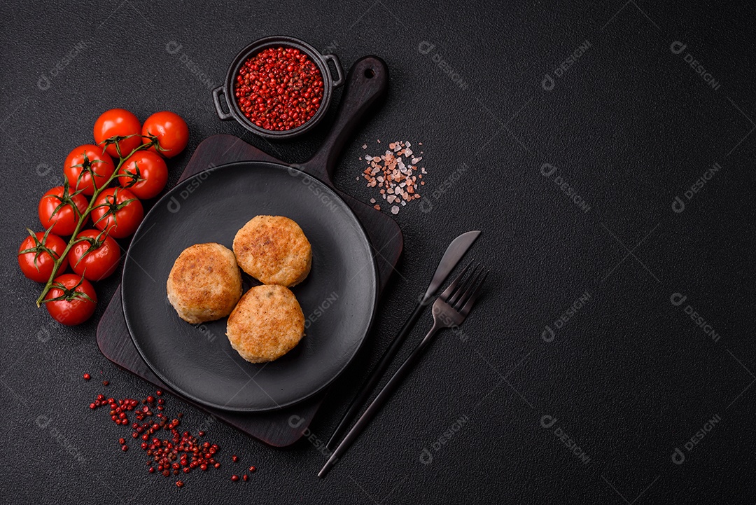 Deliciosas costeletas de peixe picado frito fresco com especiarias e ervas sobre um fundo escuro de concreto