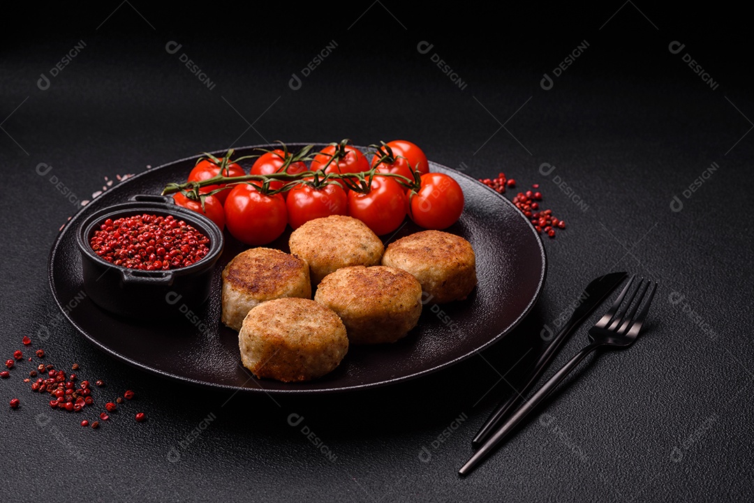 Deliciosas costeletas de peixe picado frito fresco com especiarias e ervas sobre um fundo escuro de concreto