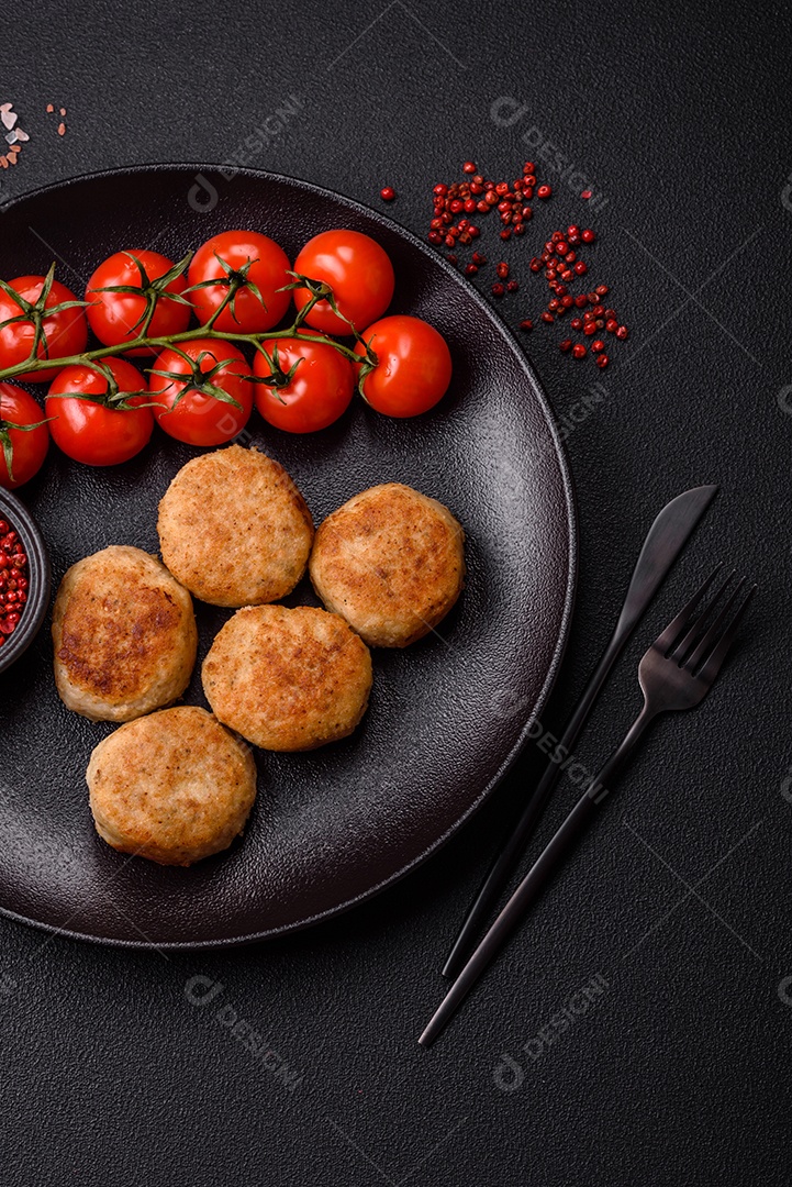 Deliciosas costeletas de peixe picado frito fresco com especiarias e ervas sobre um fundo escuro de concreto