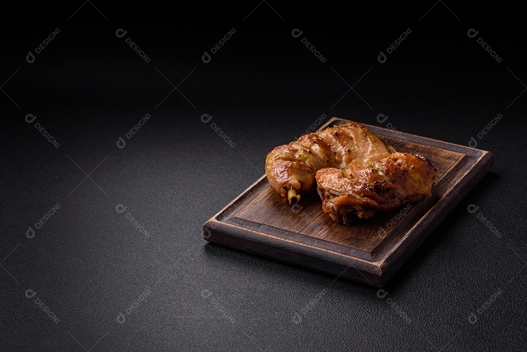 Deliciosa coxa ou quarto de frango grelhado com sal e especiarias em fundo escuro de concreto