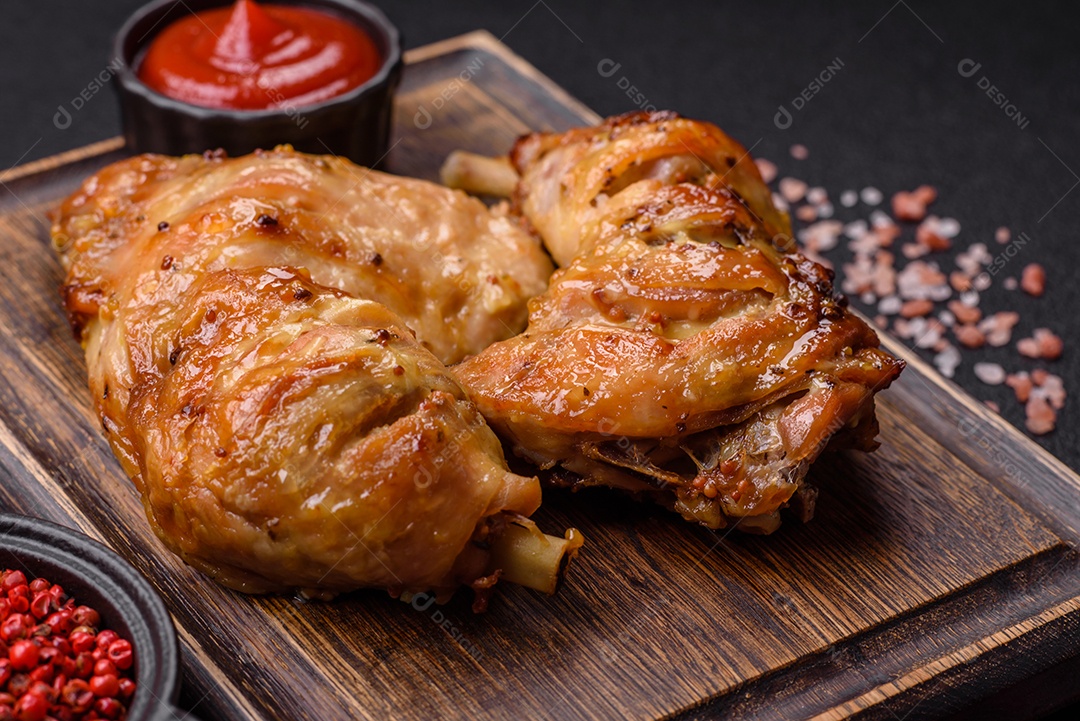 Deliciosa coxa ou quarto de frango grelhado com sal e especiarias em fundo escuro de concreto