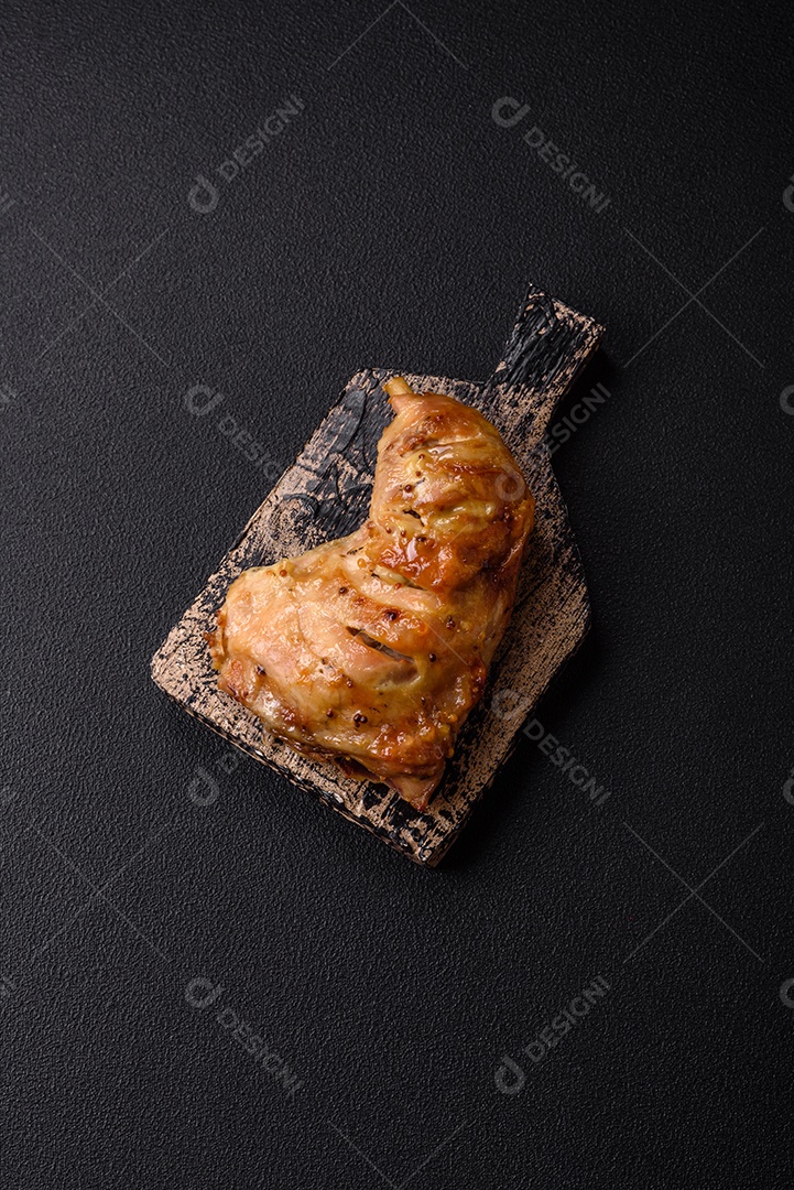 Deliciosa coxa ou quarto de frango grelhado com sal e especiarias em fundo escuro de concreto