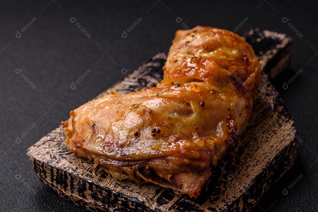 Deliciosa coxa ou quarto de frango grelhado com sal e especiarias em fundo escuro de concreto