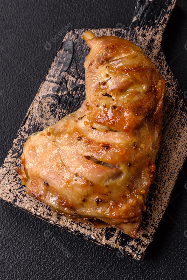 Deliciosa coxa ou quarto de frango grelhado com sal e especiarias em fundo escuro de concreto