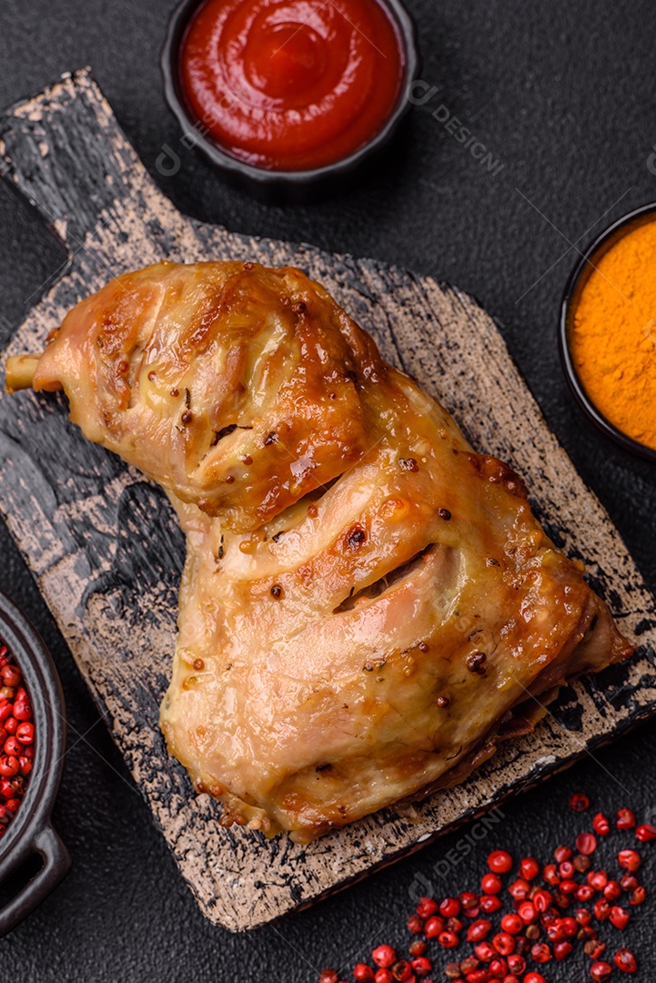 Deliciosa coxa ou quarto de frango grelhado com sal e especiarias em fundo escuro de concreto