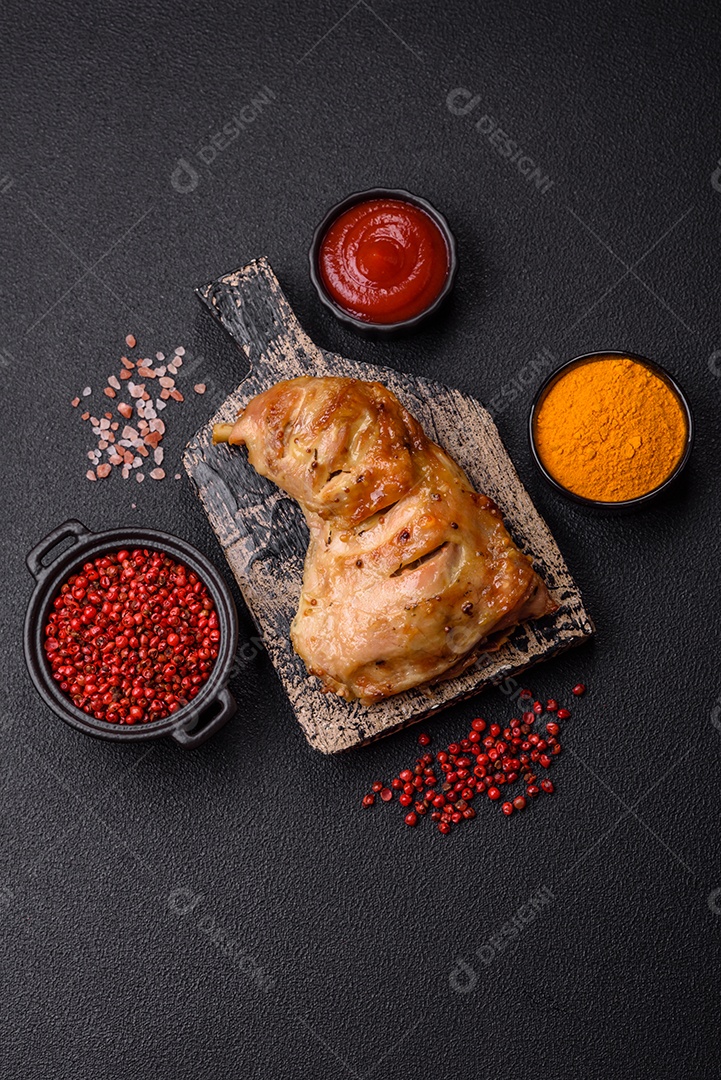 Deliciosa coxa ou quarto de frango grelhado com sal e especiarias em fundo escuro de concreto