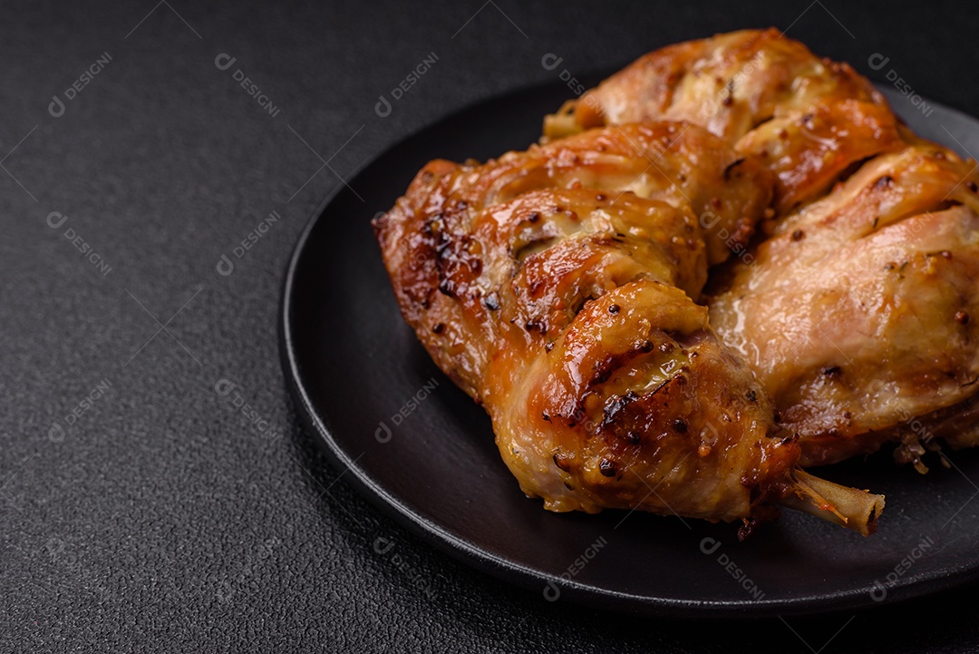 Deliciosa coxa ou quarto de frango grelhado com sal e especiarias em fundo escuro de concreto