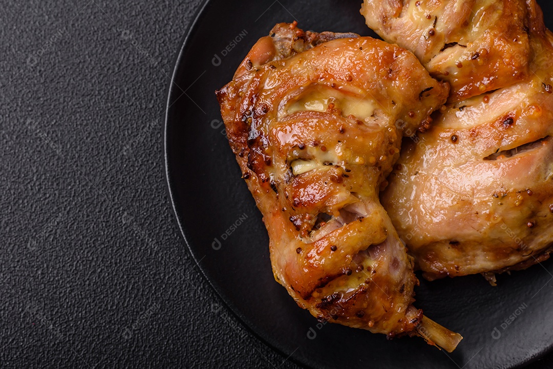 Deliciosa coxa ou quarto de frango grelhado com sal e especiarias em fundo escuro de concreto