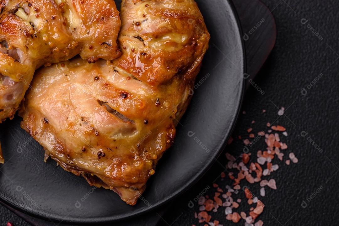 Deliciosa coxa ou quarto de frango grelhado com sal e especiarias em fundo escuro de concreto