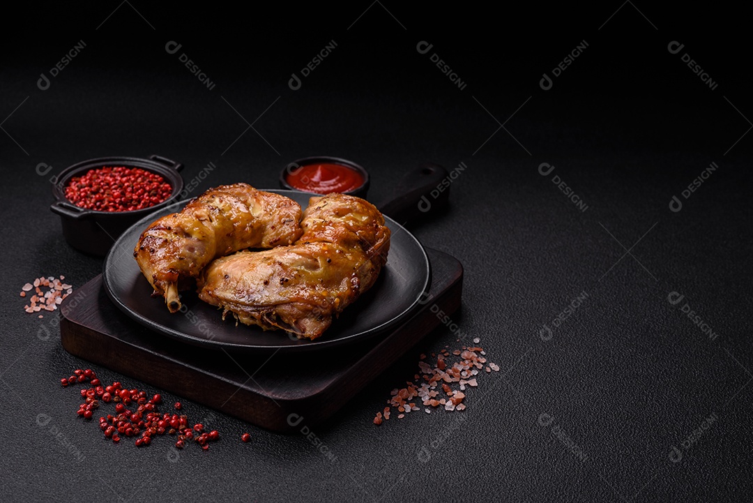 Deliciosa coxa ou quarto de frango grelhado com sal e especiarias em fundo escuro de concreto