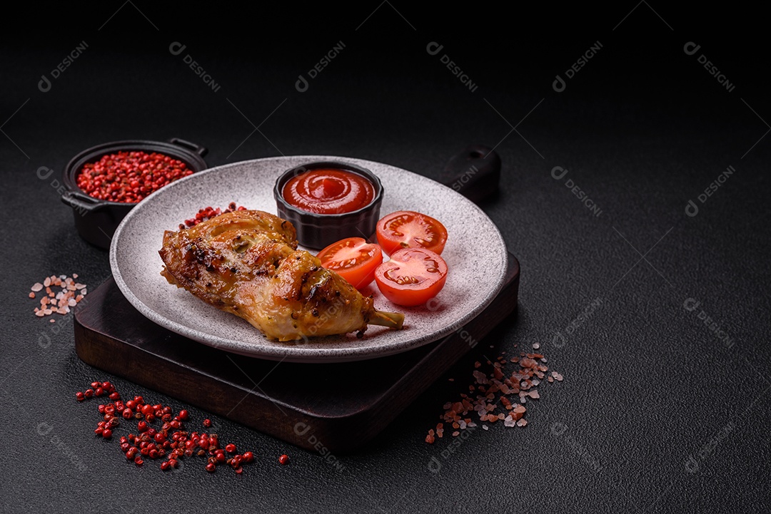 Deliciosa coxa ou quarto de frango grelhado com sal e especiarias em fundo escuro de concreto