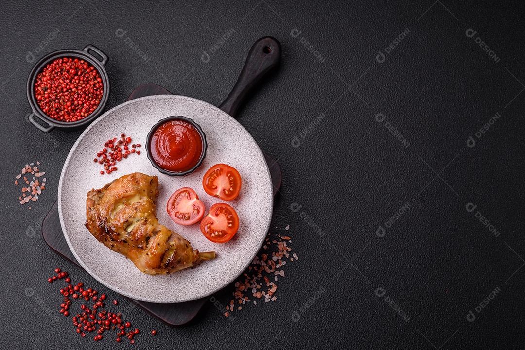 Deliciosa coxa ou quarto de frango grelhado com sal e especiarias em fundo escuro de concreto