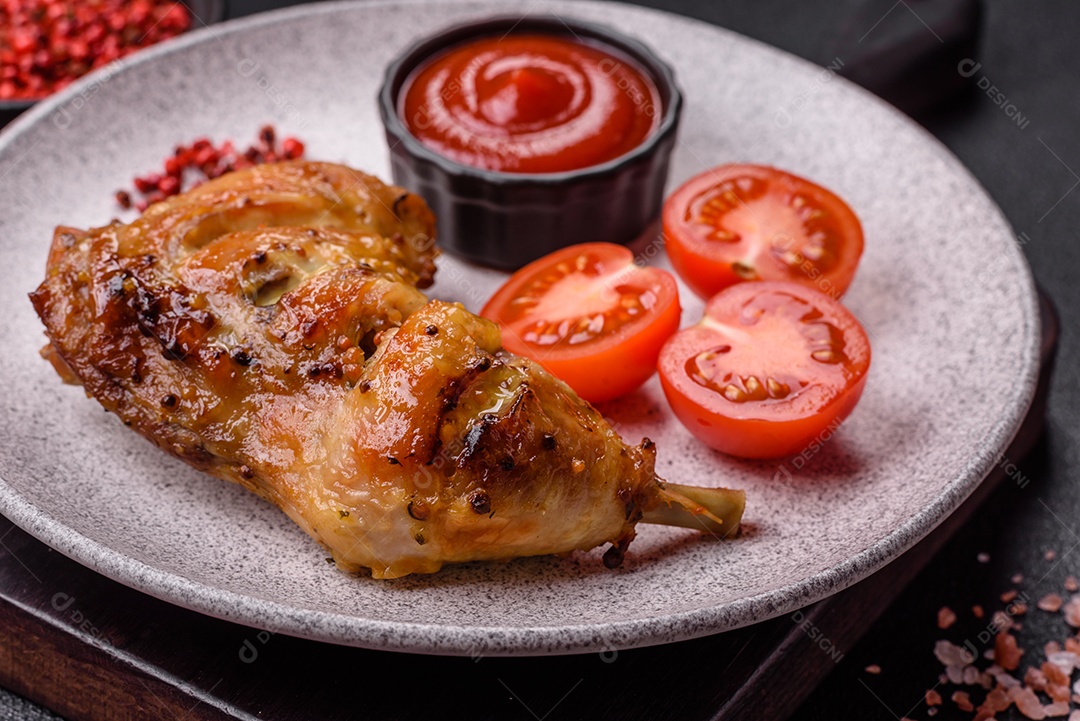 Deliciosa coxa ou quarto de frango grelhado com sal e especiarias em fundo escuro de concreto