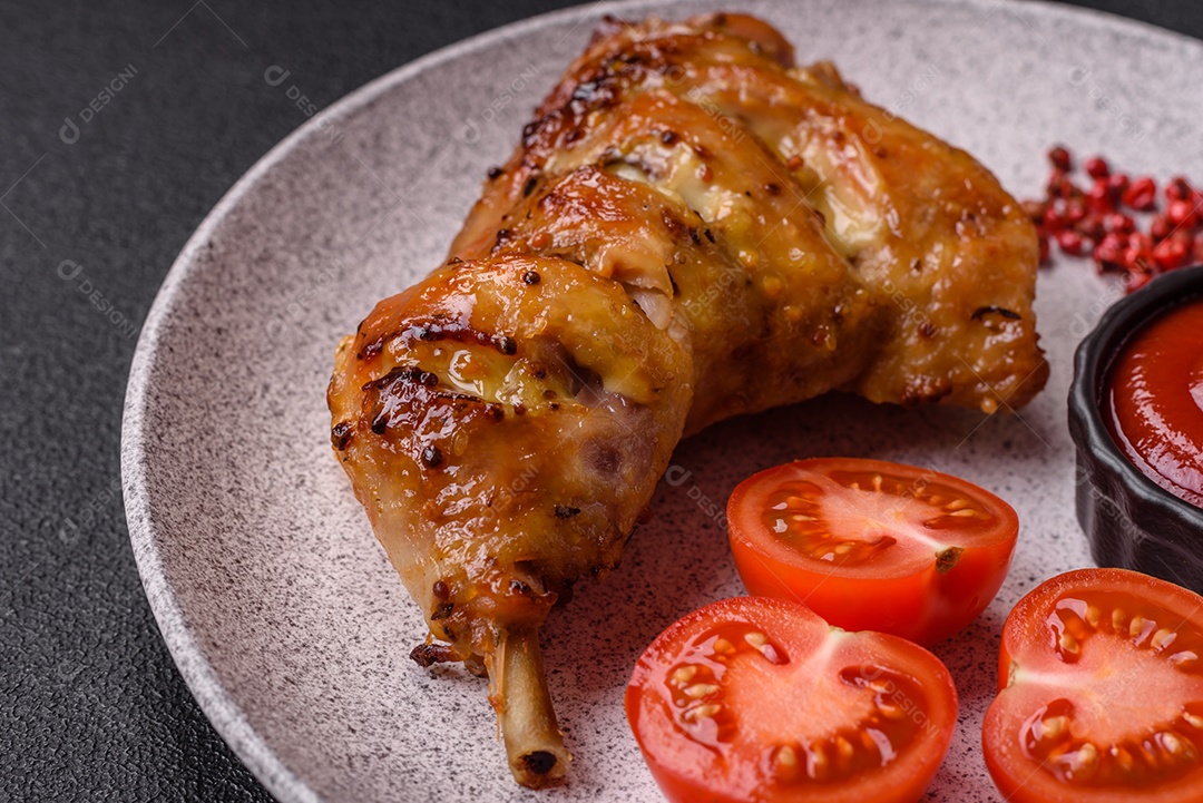 Deliciosa coxa ou quarto de frango grelhado com sal e especiarias em fundo escuro de concreto
