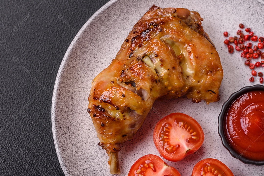 Deliciosa coxa ou quarto de frango grelhado com sal e especiarias em fundo escuro de concreto